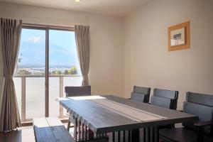 a dining room with a table and chairs and a large window at Villas Asama no Iori in Fujiyoshida