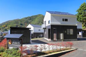 a white and black building with a mountain in the background at Villas Asama no Iori in Fujiyoshida