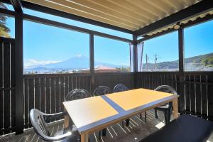 a table and chairs on a deck with a view of a mountain at Villas Asama no Iori in Fujiyoshida
