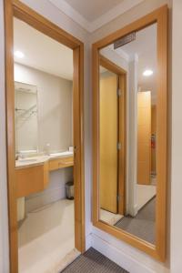 La salle de bains est pourvue d'un miroir et d'un lavabo. dans l'établissement (103)Flat Executive Jardins (Apt. particular), à São Paulo