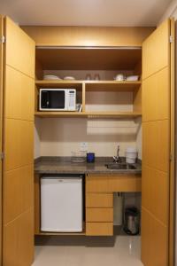 cocina con fregadero y microondas en (103)Flat Executive Jardins (Apt. particular), en São Paulo
