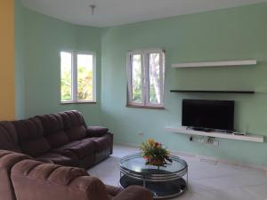 a living room with a couch and a tv at Villas Michaela Caribbean in Sosúa