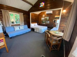 um quarto com um sofá, uma cama e uma mesa em Paihia Place Cottage - central Paihia em Paihia