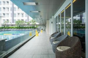 un edificio con piscina e sedie accanto a un edificio di Apartemen Taman Melati Yogyakarta by ArFe Room a Sleman Altre 8 foto