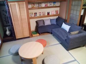 salon z niebieską kanapą i stołem w obiekcie Kyoto Villa Kotone w mieście Kioto