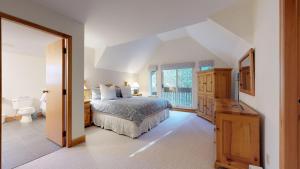 een grote slaapkamer met een bed en een raam bij Lush Forest and Golf Course Views by Harmony Whistler in Whistler