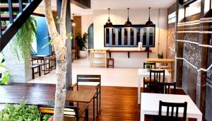 un restaurante con mesas, sillas y un árbol en Kallapangha Resort Khlongwan, en Klong Wan