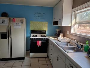 La cuisine est équipée d'un réfrigérateur, d'une cuisinière et d'un évier. dans l'établissement Yosemite International Hostel, à Groveland
