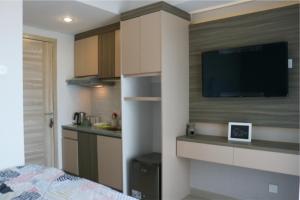 a room with a bed and a tv on a wall at Apartemen Taman Melati Yogyakarta by ArFe Room in Sleman