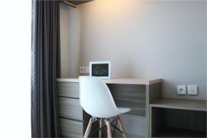 a white chair sitting next to a desk in a room at Apartemen Taman Melati Yogyakarta by ArFe Room in Sleman +11 photos