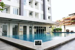 a swimming pool in front of a building at Apartemen Taman Melati Yogyakarta by ArFe Room in Sleman