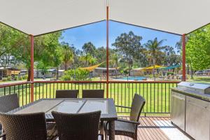 a patio with a table and chairs and a pool at Discovery Parks - Moama West in Moama