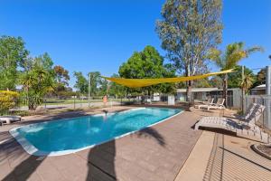 a hammock is hanging over a swimming pool at Discovery Parks - Moama West in Moama