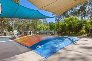 a blue umbrella sitting on top of a green field at Discovery Parks - Moama West in Moama