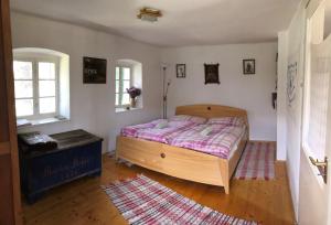 ein Schlafzimmer mit einem Holzbett und einem Teppich in der Unterkunft Erdősmecskei sváb vendégházak és Jurtaszállás in Erdősmecske
