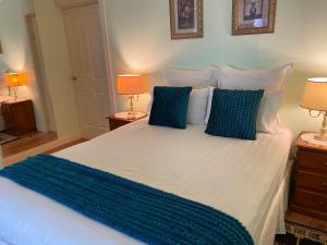 a bedroom with a large white bed with blue pillows at Curtis Falls Studio-Apartment in Mount Tamborine