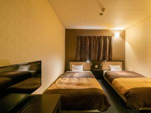 a hotel room with two beds and a flat screen tv at Kyoto Central Inn in Kyoto
