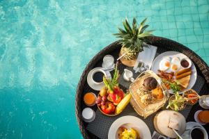 a tray of breakfast food next to a swimming pool at The Canale Samui Resort in Chaweng