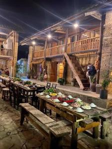 a group of wooden tables with plates of food on them at homestay bongbang in Ha Giang