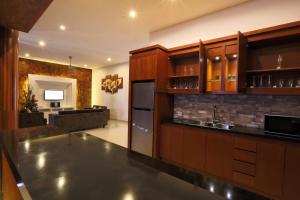a kitchen with wooden cabinets and a counter top at Bale Gede Luxury Villas in Seminyak