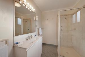 a bathroom with a sink, mirror, and bathtub at Discovery Parks - Pambula Beach in Pambula