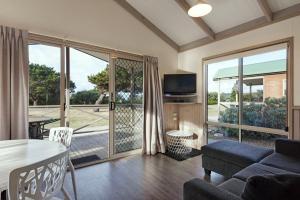 a living room filled with furniture and a tv at Discovery Parks - Pambula Beach in Pambula