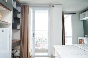 a bedroom with a bed and a large glass door at Apartemen Taman Melati Yogyakarta by ArFe Room in Yogyakarta +11 photos