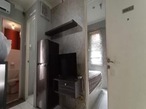 Sewaunitkalcit في جاكرتا: مطبخ مع ثلاجة ستانلس ستيل وغرفة نوم