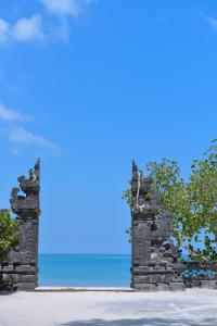 an entrance to a beach with the ocean in the background at The Open House Jimbaran Bali in Jimbaran