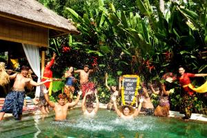 eine Gruppe von Menschen im Wasser in einem Resort in der Unterkunft The Open House Jimbaran Bali in Jimbaran