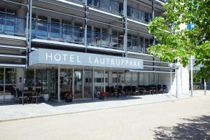 a hotel building with tables and chairs in front of it at Hotel Lautrup Park in Ballerup