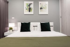 a bedroom with a large bed with green pillows at LKN Grand in Bangkok