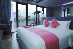 um quarto com uma cama grande e almofadas cor-de-rosa em HOME Hotel em Ho Chi Minh