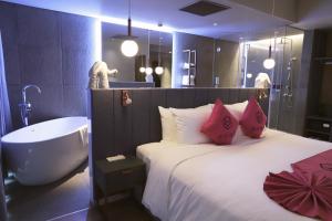 a bedroom with a large bed and a bath tub at HOME Hotel in Ho Chi Minh City