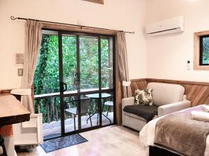 a living room with a bed and a sliding glass door at Te Nikau Retreat in Punakaiki