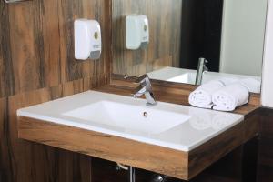 a bathroom with a sink and a mirror and towels at Hotel Planet Four in Lonavala