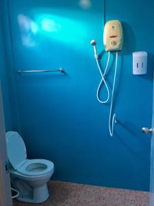 a bathroom with a toilet and a blue wall at Insook Ko Larn Resort in Ko Larn