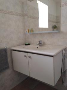 W łazience znajduje się biała umywalka i lustro. w obiekcie A deux pas de St Cirq Lapopie , Gite des Murets de l'isa w mieście Esclauzels