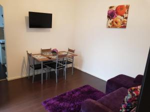 a living room with a dining room table with a purple rug at Apartament 12 Central in Târgu-Mureş