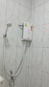 a shower head with a hose attached to a wall at Thongsuk Mini Resort in Ban Nong Ban Kao