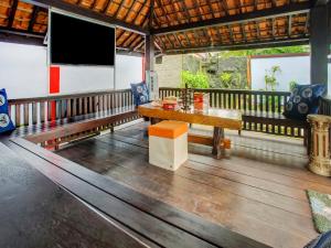 a dining room with a table and a flat screen tv at OYO 3982 Azka Homestay Syariah in Bandar Lampung