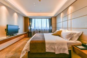 a bedroom with a large bed and a television at Guilin Plaza Hotel in Guilin