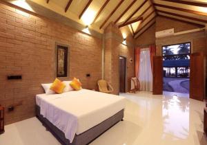 1 dormitorio con cama y pared de ladrillo en Twin Waters Resort, en Chilaw