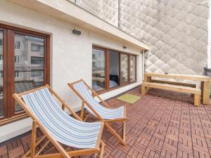 twee stoelen op een veranda met een bank bij Kreef in Oostende