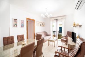 ein Esszimmer und ein Wohnzimmer mit Tisch und Stühlen in der Unterkunft Apartamento Conil Centro in Conil de la Frontera
