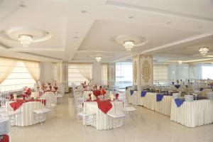 a banquet hall with white tables and chairs at Grand Mongolia Hotel in Rawalpindi