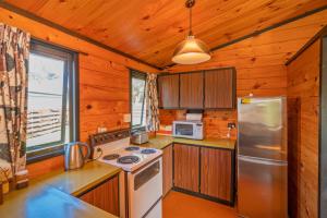 Il comprend une cuisine équipée d'une cuisinière et d'un réfrigérateur. dans l'établissement Retro Revival - Pauanui Holiday Home, à Pauanui