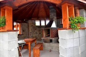 an outdoor kitchen with a fireplace and a table at Penzion Jantoľák in Zuberec