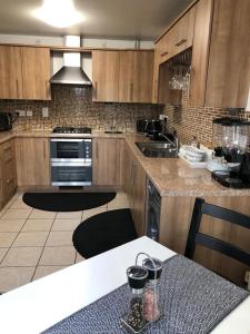 a kitchen with wooden cabinets and a table and a stove at Home Away from Home 