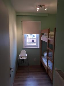 a small room with two bunk beds and a window at Résidence Jersey (app. 201) in Koksijde